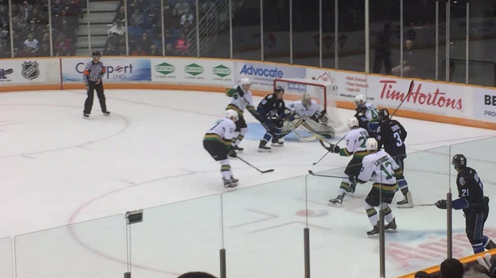 Une mêlée de hockeyeurs devant le filet