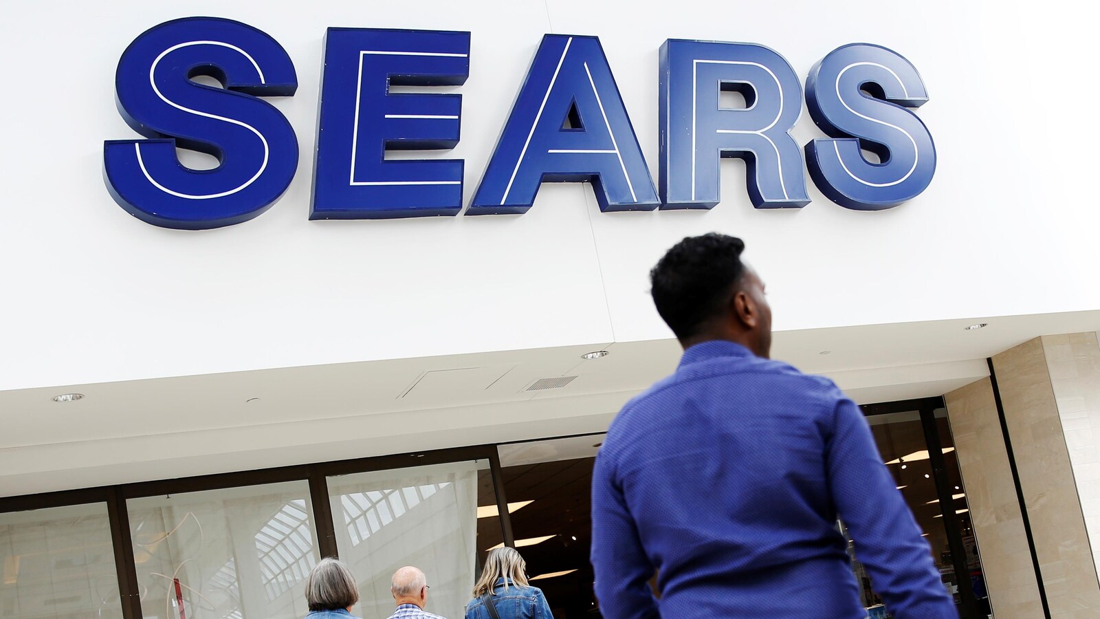 Un homme devant un magasin Sears