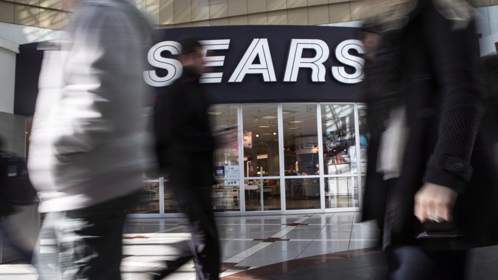 Des gens marchent près d'un magasin Sears à Toronto.