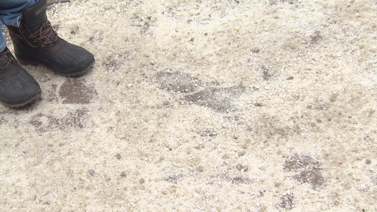 Photo d'une paire de bottes sur un trottoir recouvert de sel blanc