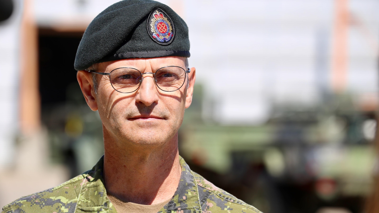 Un militaire porte l'habit de camouflage et le béret.