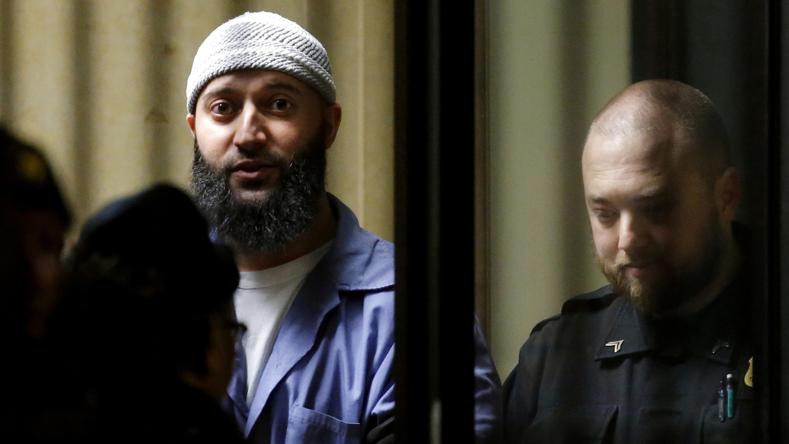 Adnan Syed, lors de son procès, arbore un uniforme de prisonnier et une longue barbe