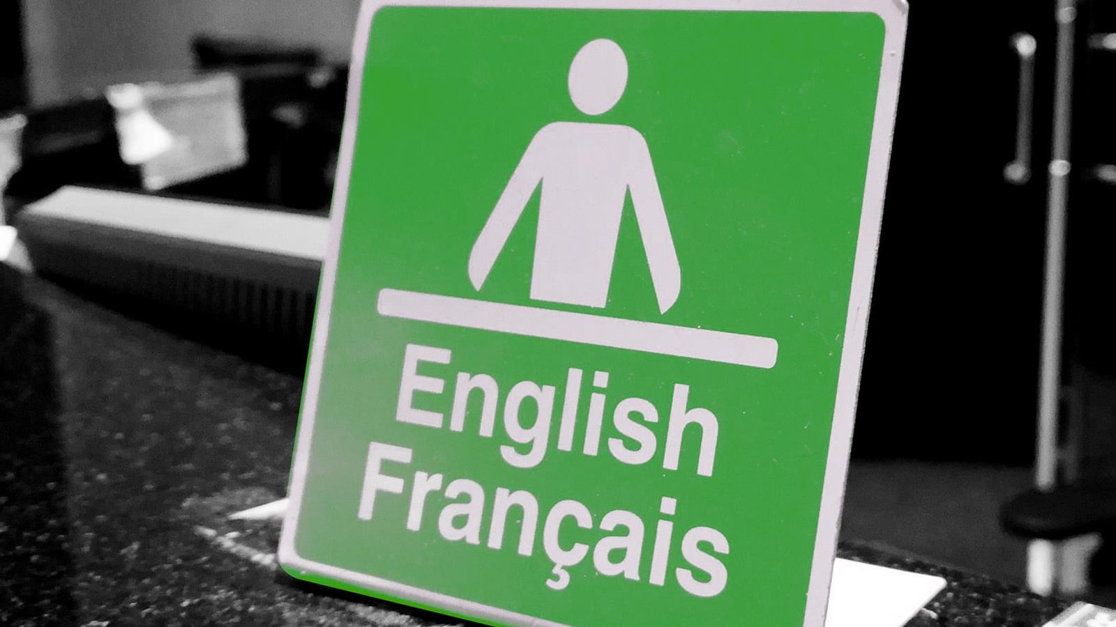 Une affiche où s'est écrit english français avec une icône d'un homme devant un bureau.