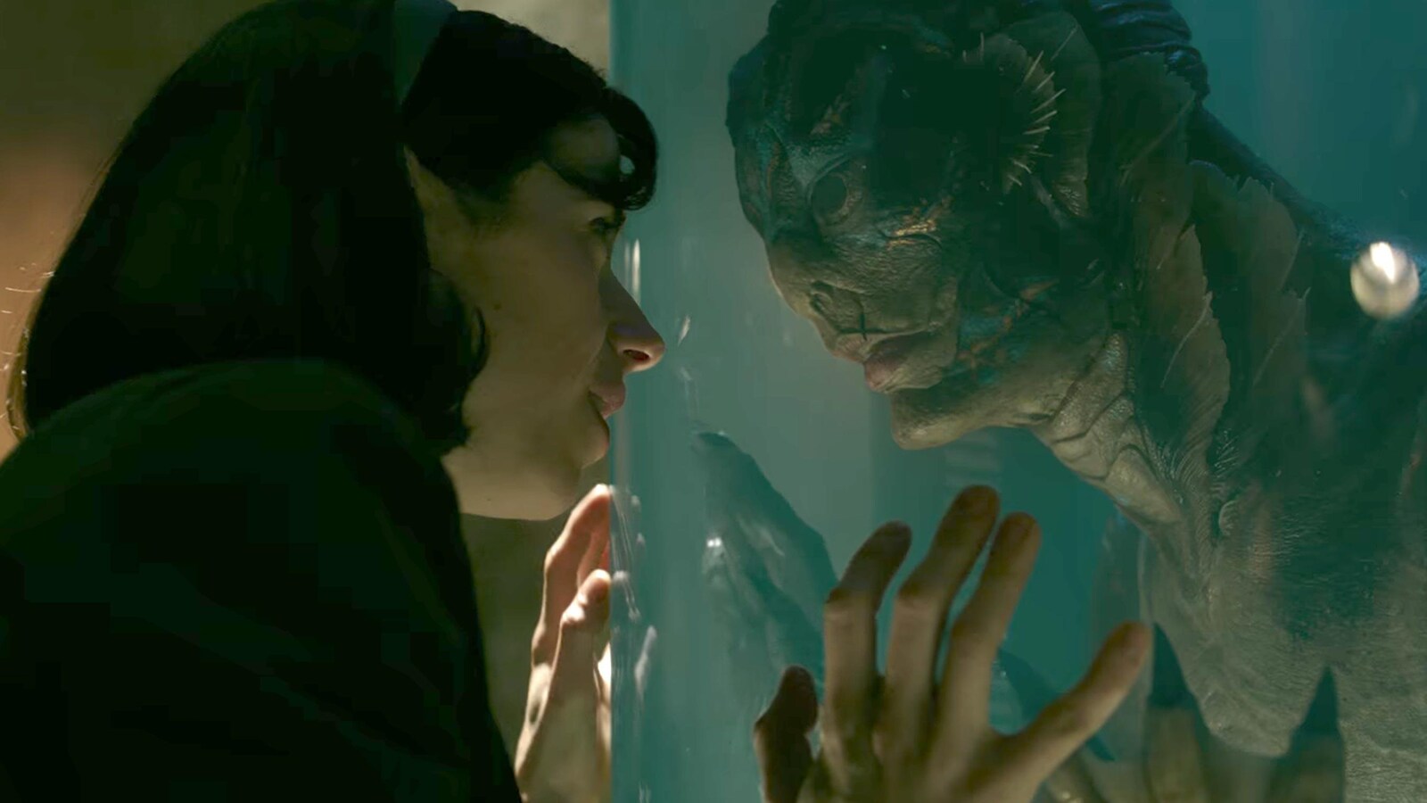 Sally Hawkins regarde avec la créature à travers la vitre de son aquarium, dans le film The Shape of Water.