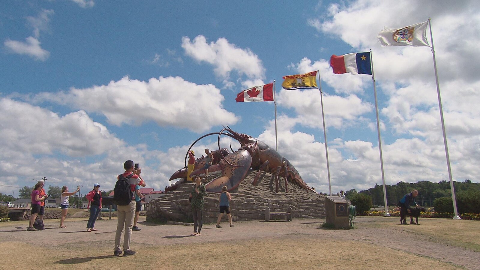 Des touristes se prennent en photo devant le homard géant, à Shediac.