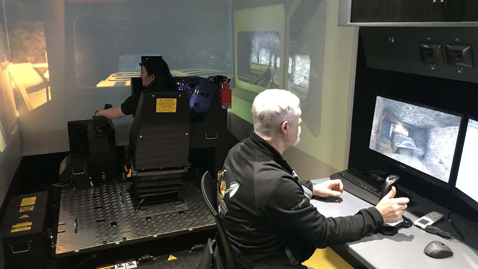 Un homme et une femme opèrent un simulateur minier.