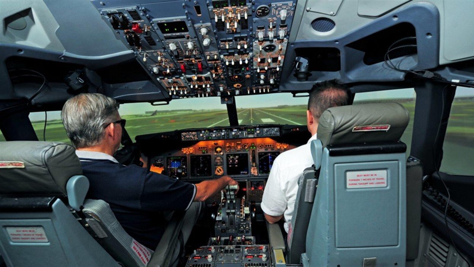 Un pilote en formation dans un simulateur de vol construit par CAE