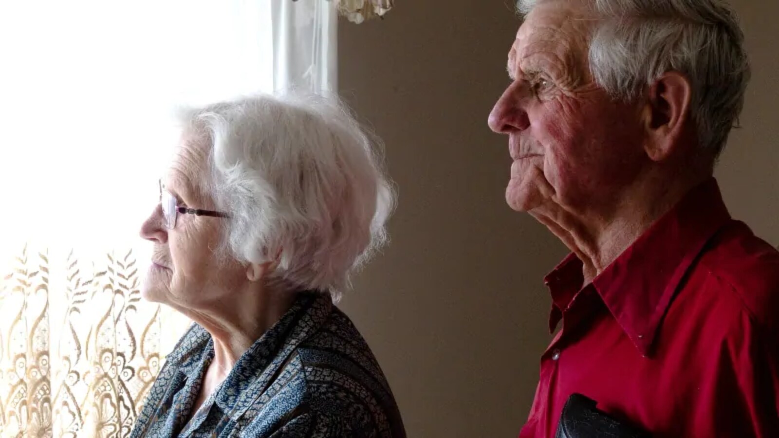 Un homme et une femme regardent par la fenêtre.