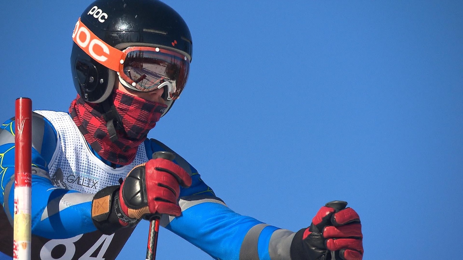 Un skieur, coiffé d'un casque et de ses lunettes, se prépare pour son départ.