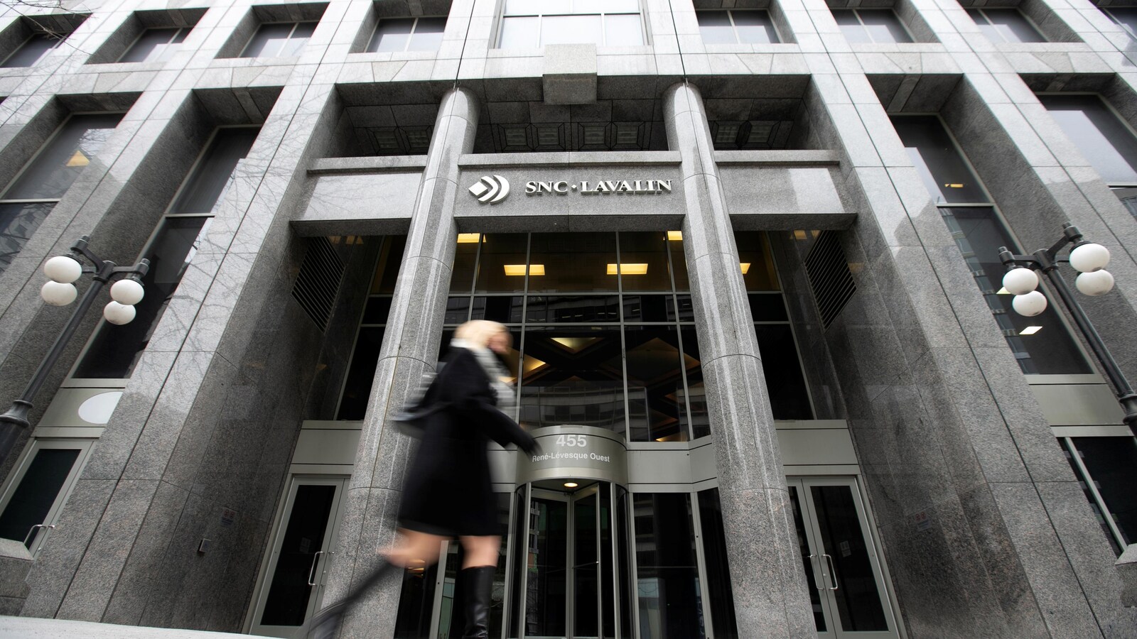 Une piétonne passe devant le siège social de SNC-Lavalin à Montréal.
