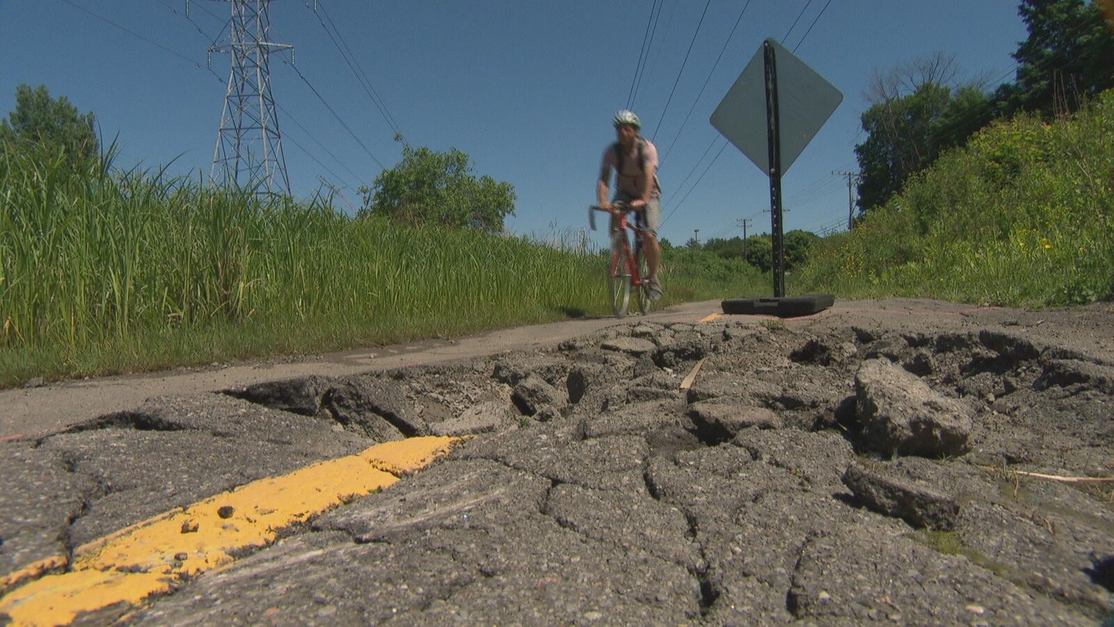 un cycliste évite une section endommagée d'un sentier polyvalent (piste cyclable) à Gatineau.