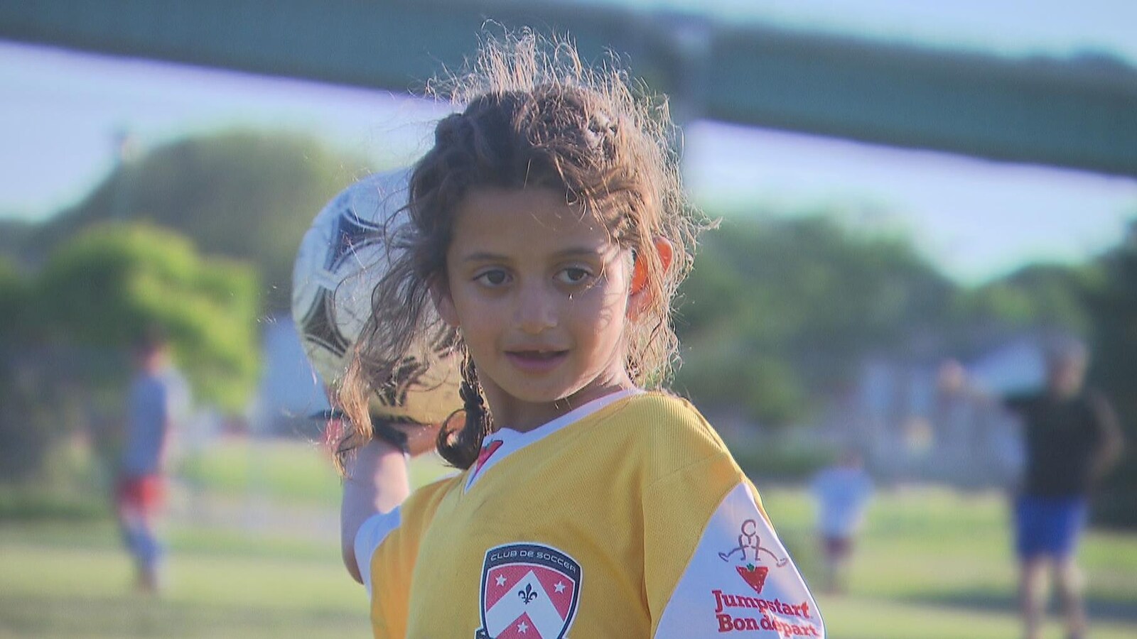 La jeune fille tient un ballon dans sa main droite