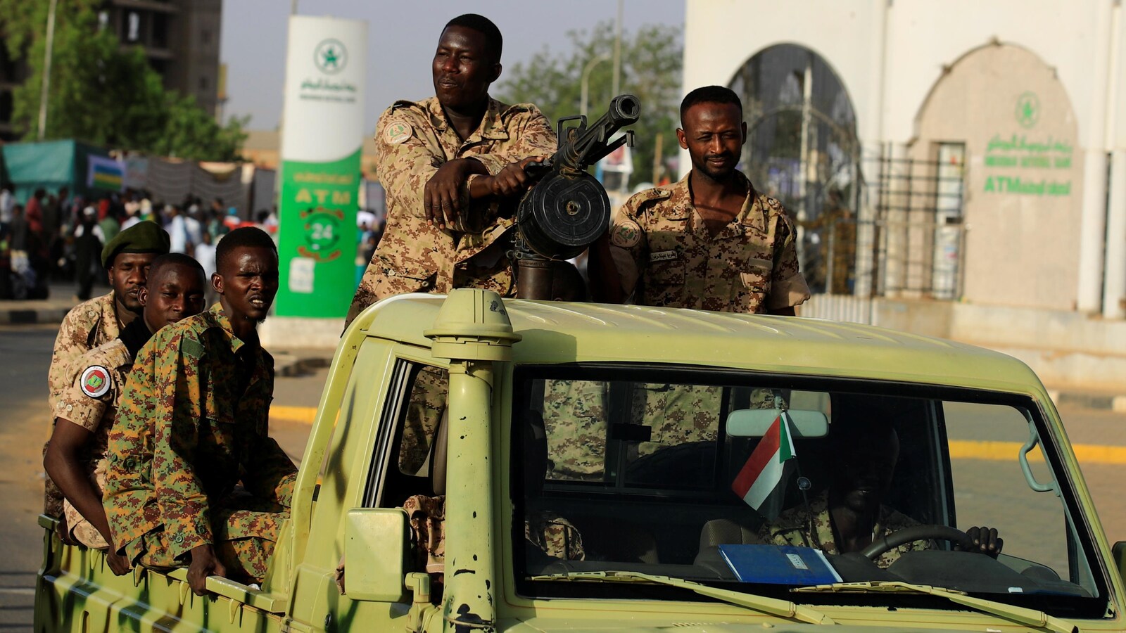 Des soldats soudanais à bord d'un véhicule de l'armée alors qu'ils traversent le complexe du ministère de la Défense à Khartoum.