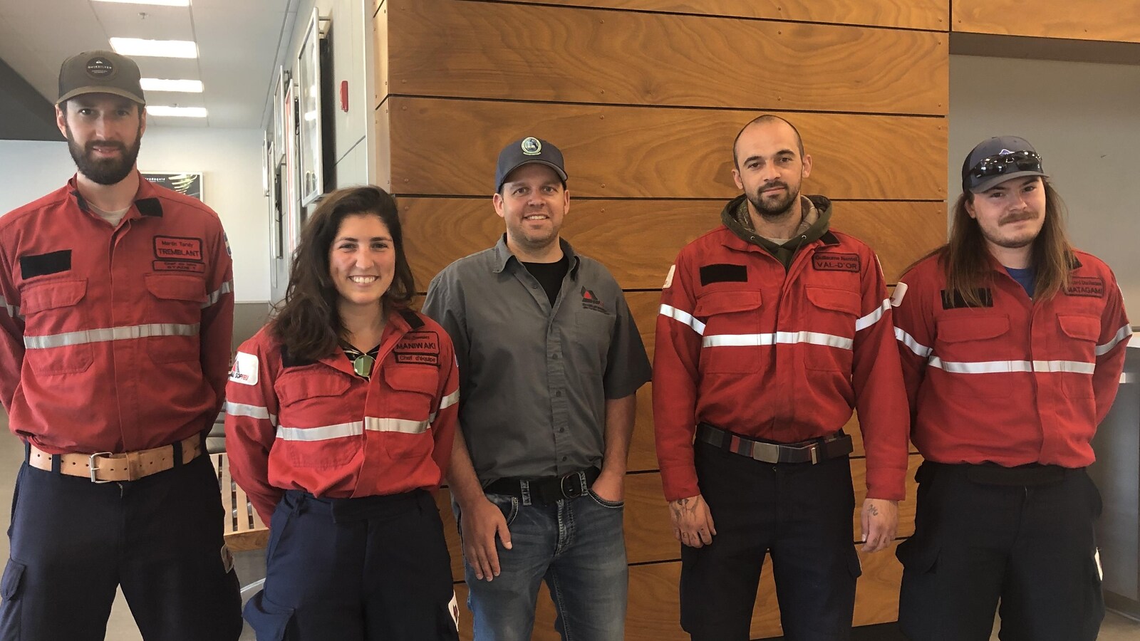 Cinq employés de la SOPFEU posent côte à côte à l'aéroport de Val-d'Or.