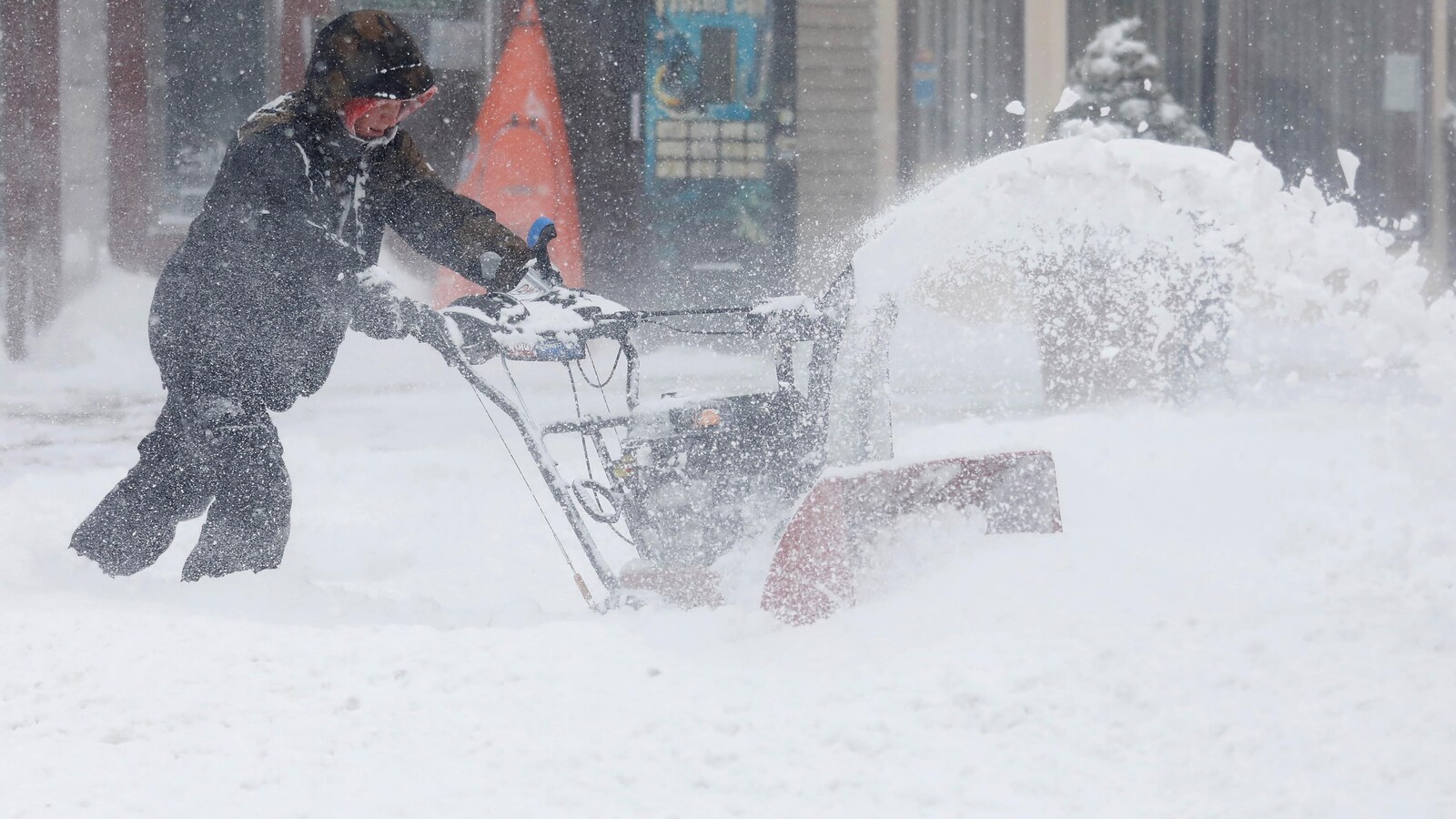 Un homme utilise une souffleuse à neige à Port Washington à New York.