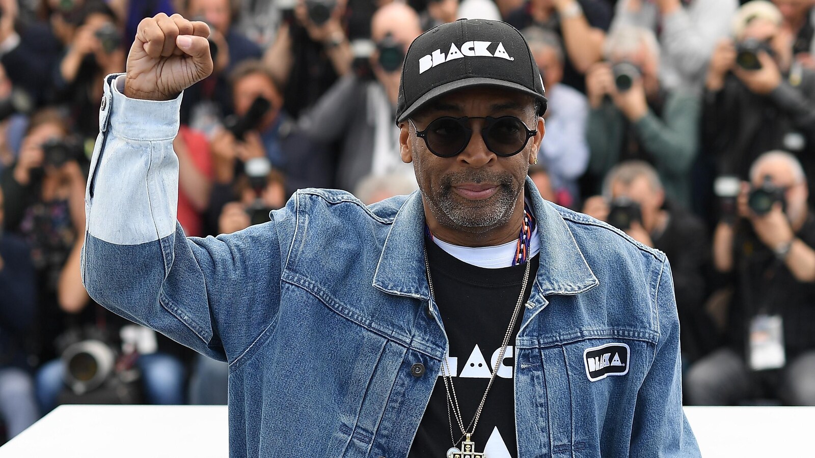 Spike Lee brandit son poing droit lors d'un événement médiatique au Festival de Cannes 2018.