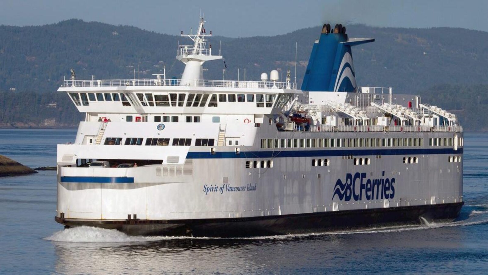 Le traversier Spirit of Vancouver Island, un gros bateau blanc et bleu, est dans l'eau.