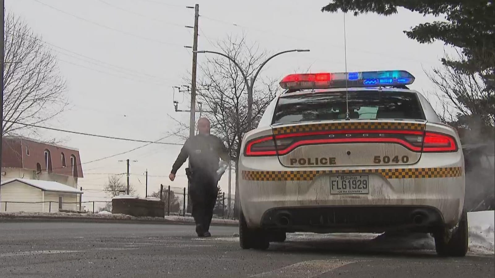 Un agent qui se dirige vers son véhicule dans la rue, l'hiver