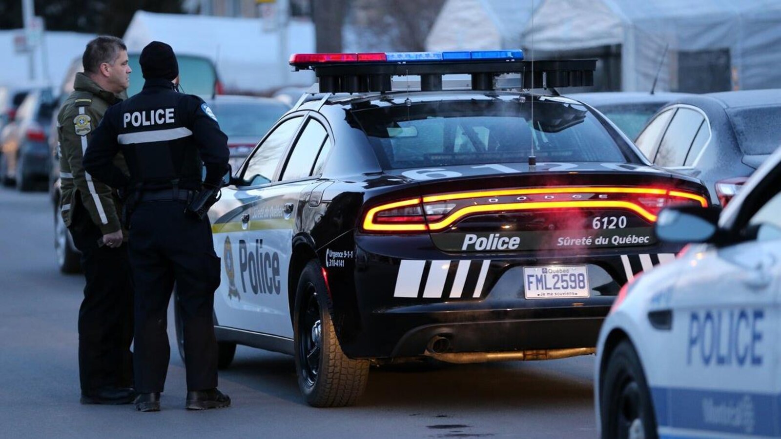 Des policiers discutent près d'une autopatrouille.