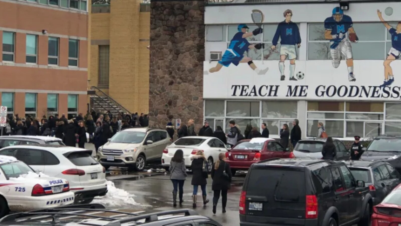Des parents d'élèves devant une école.