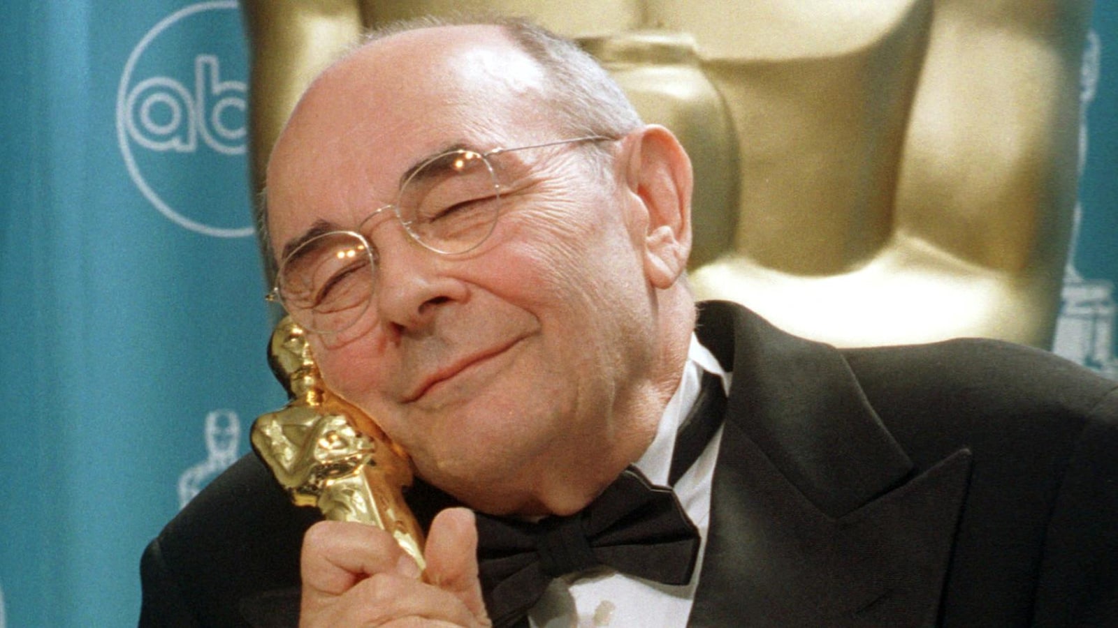 Stanley Donen serre sa statuette contre sa joue lors de la cérémonie des Oscars, le 23 mars 1998.