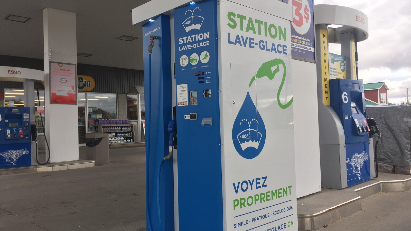 À côté d'une pompe à essence, une pompe à lave-glace qui utilise sensiblement le même procédé pour distribuer du lave-glace aux clients.