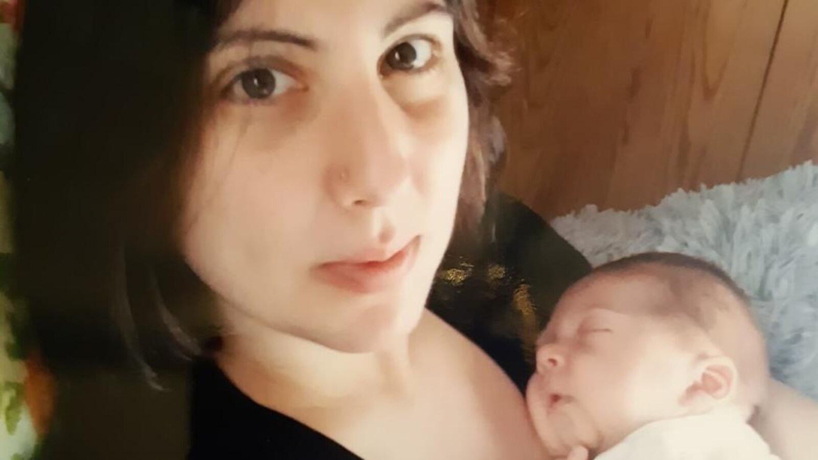 La jeune maman Stefania Seccia porte son bébé endormi dans les bras alors qu'elle est assise.