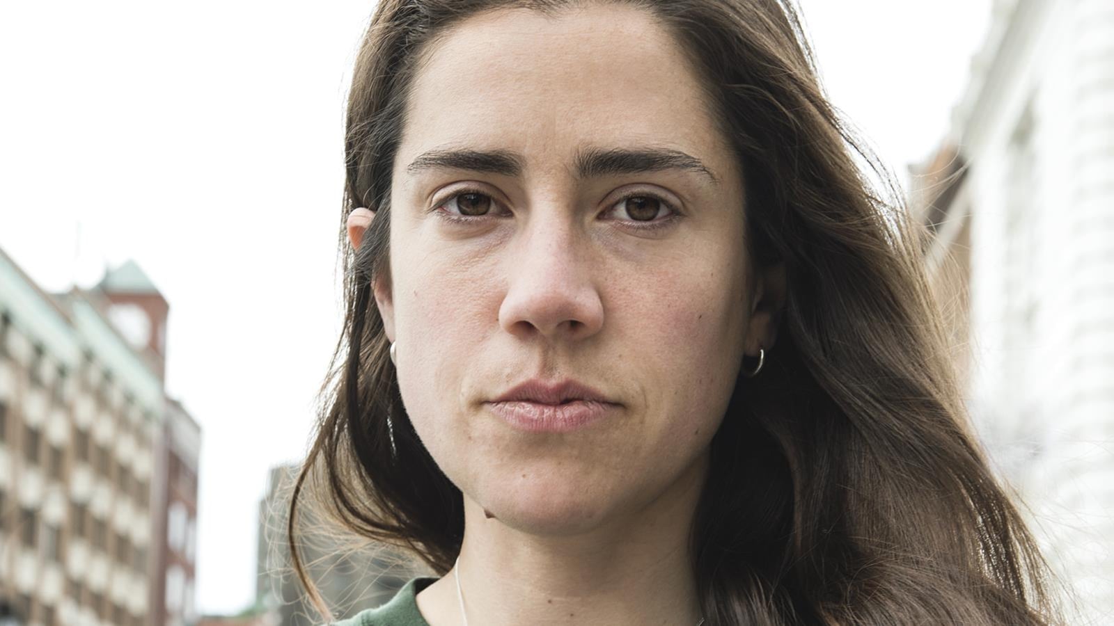 Portrait de l'auteure Stéfanie Clermont en chandail vert, cheveux châtains longs lâchés portés sur le côté gauche.