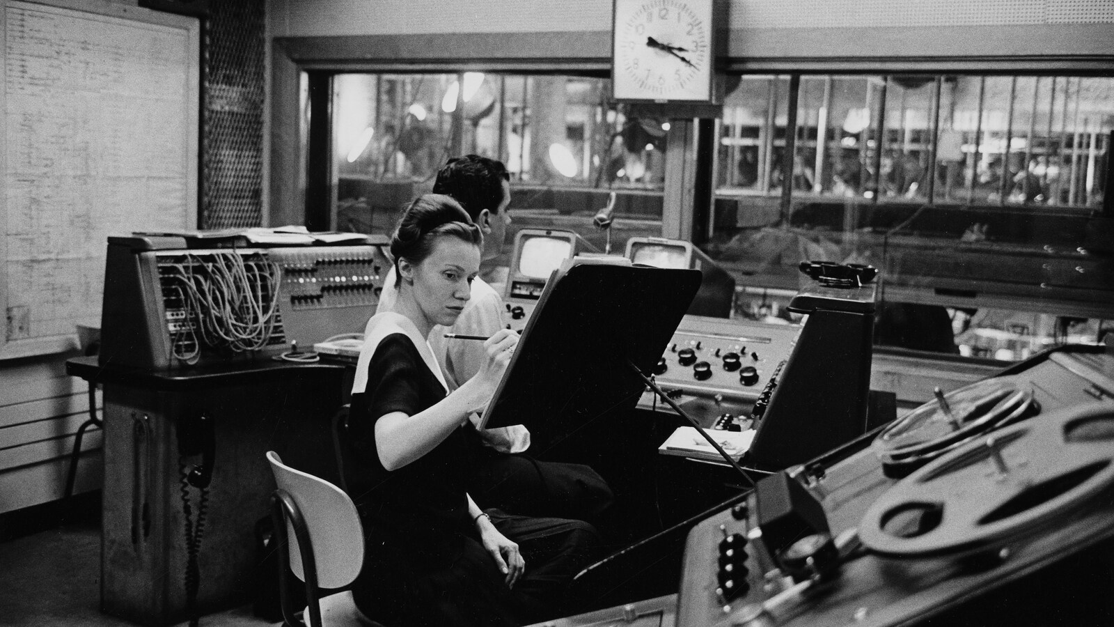 Pauline Paré et Patrick Jackson sont concentrés, devant des consoles en régie.