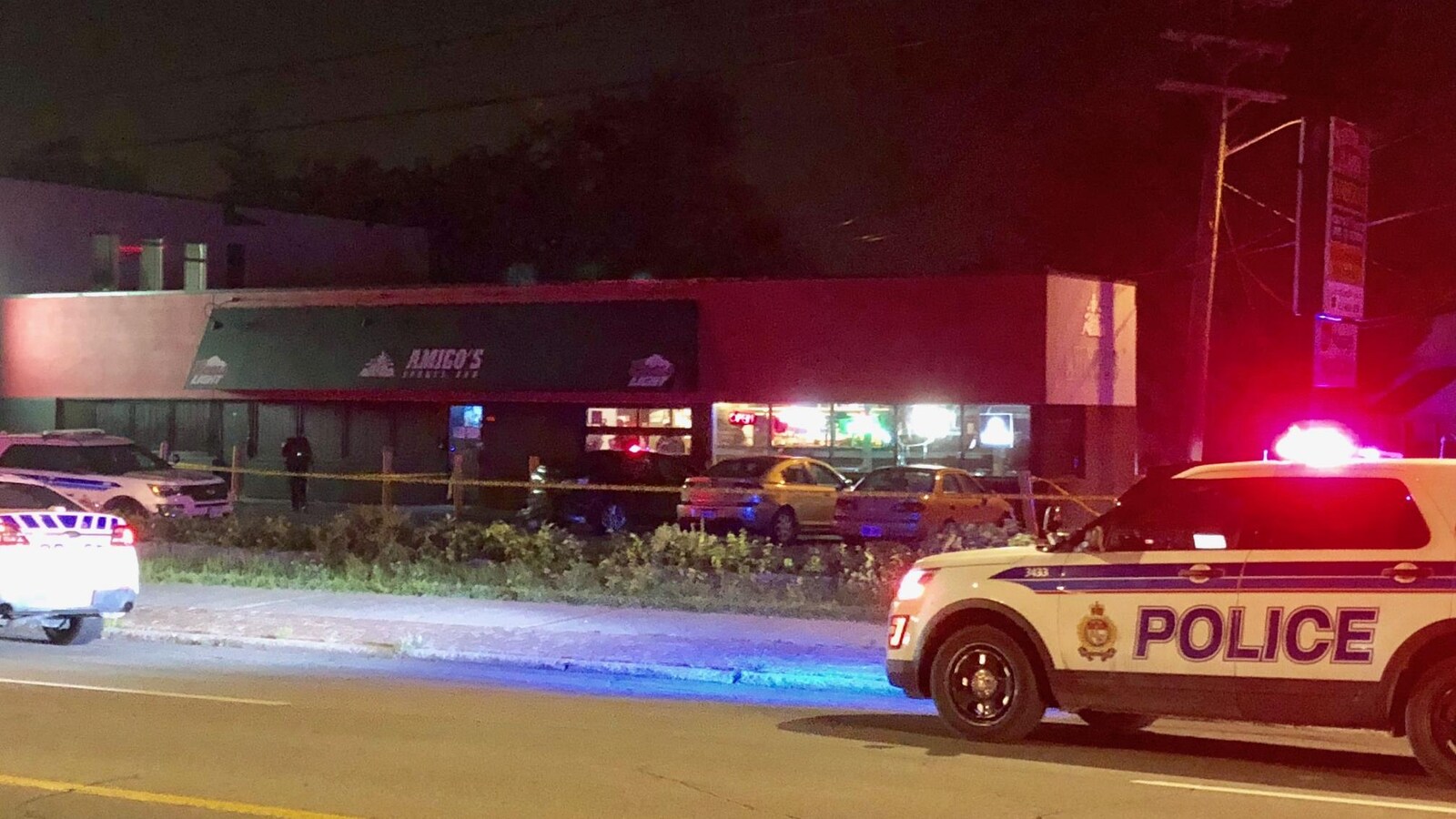 Deux voitures de police devant des commerces.