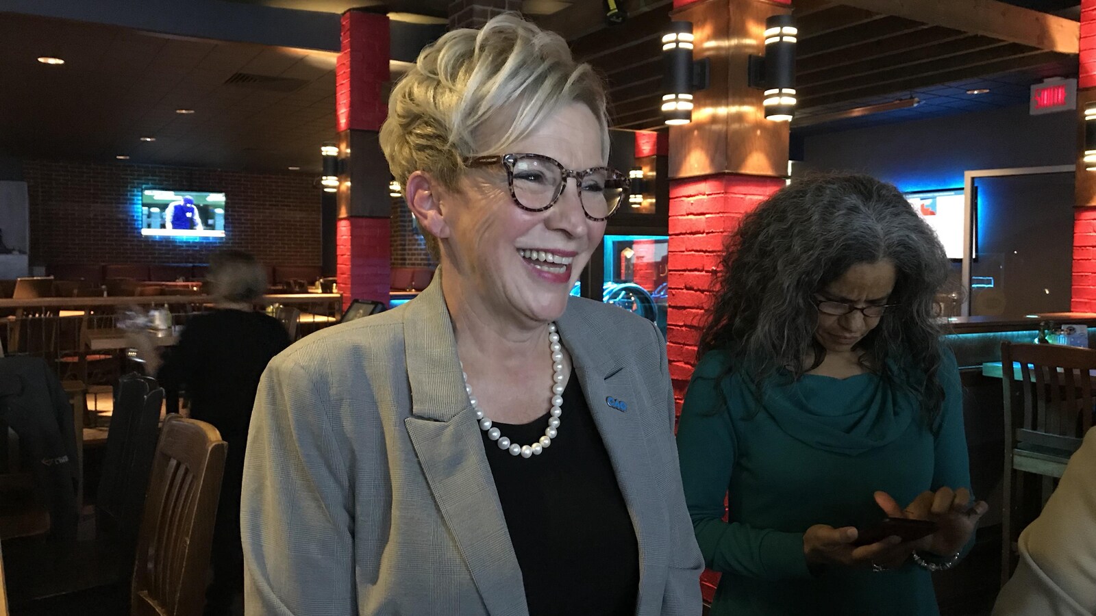 Suzanne Blais sourit en parlant à quelqu'un hors champ.