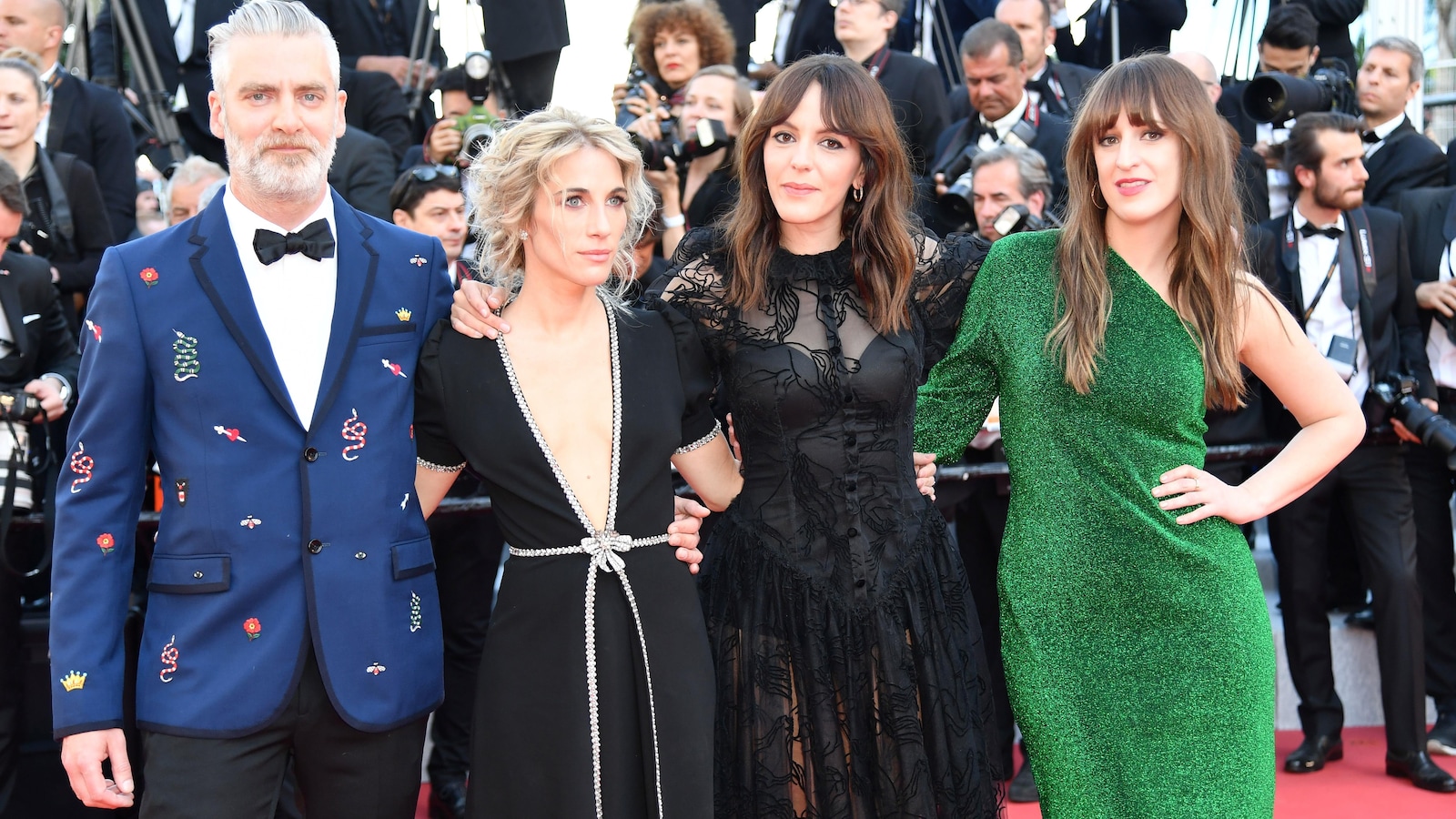Les quatre personnes posent côte à côte en robes et costumes de soirée.