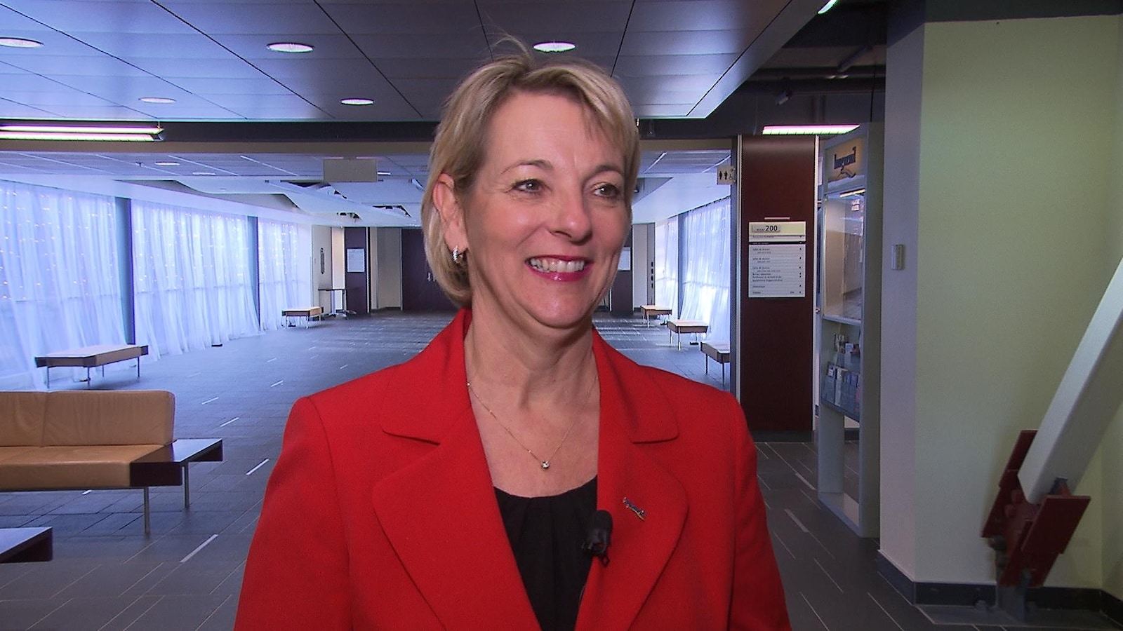 Sylvie Parent, tout sourire, portant un veston rouge.