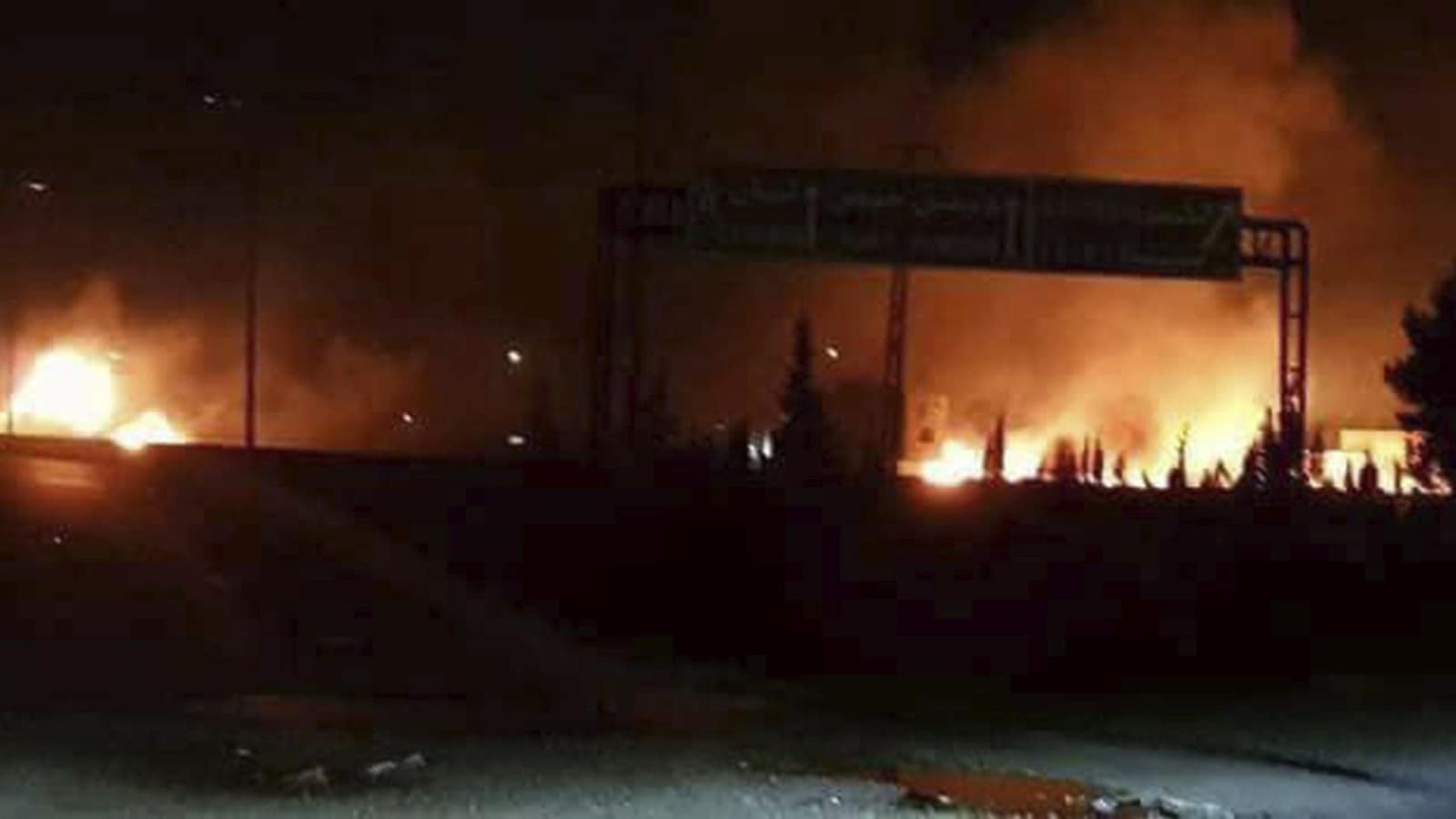 Cette photo rendue publique par l'agence de presse officielle syrienne SANA, montre des flammes se levant après une attaque dans une zone connue pour avoir de nombreuses bases militaires de l'armée syrienne, à Kisweh, au sud de Damas, en Syrie.