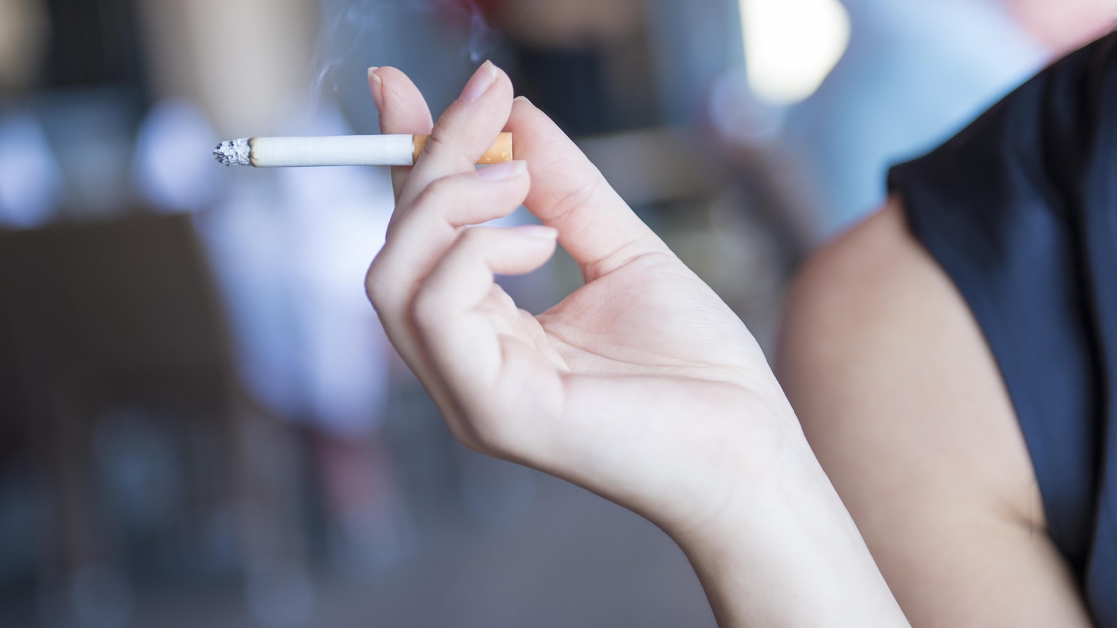 Une femme tient une cigarette dans sa main