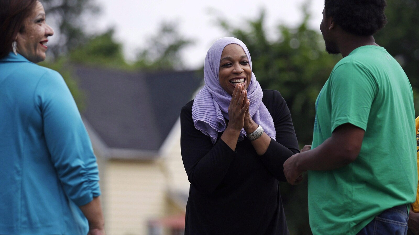 Tahirah Amatul-Wadud, entourée d'une femme et d'un homme.