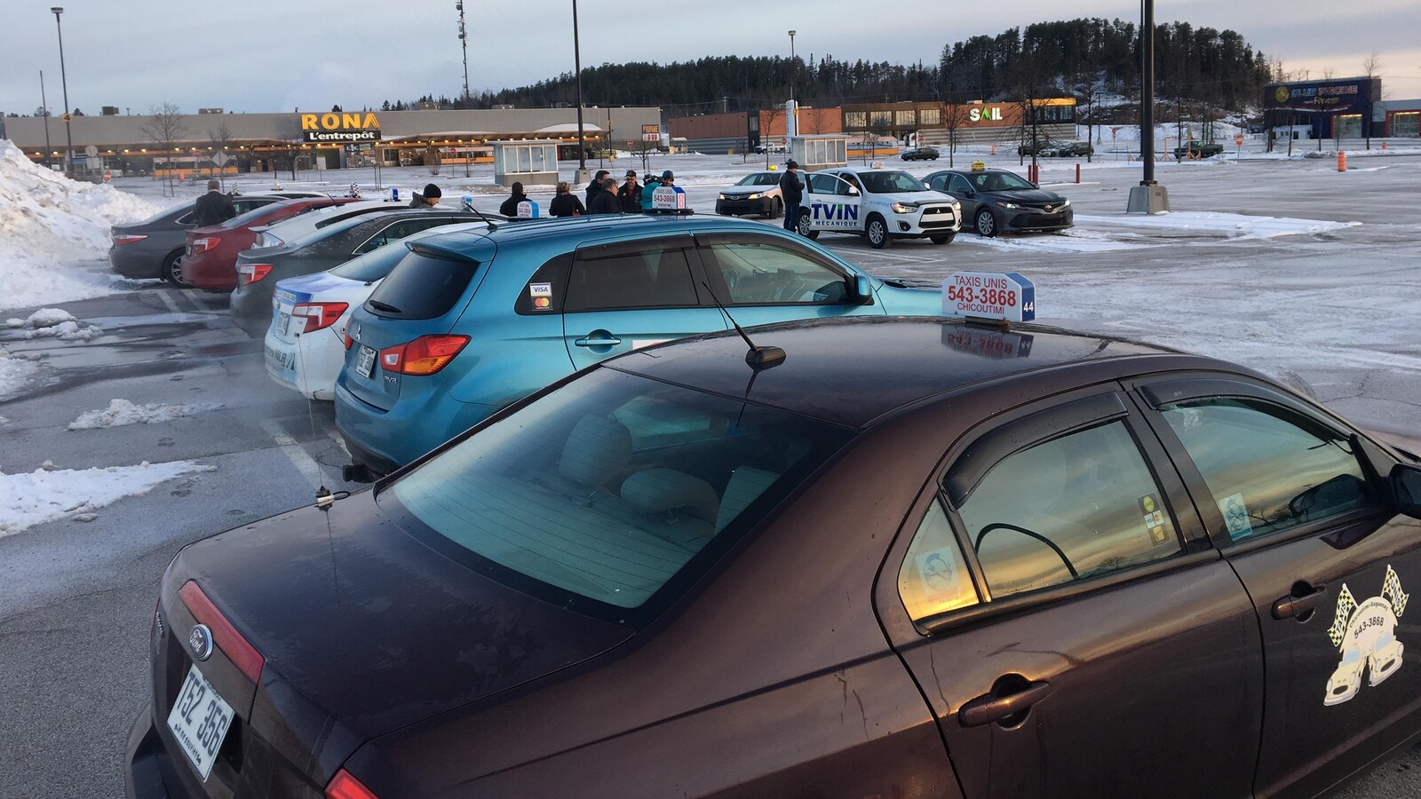 Des voitures de taxi stationnées près du magasin Rona à Chicoutimi.