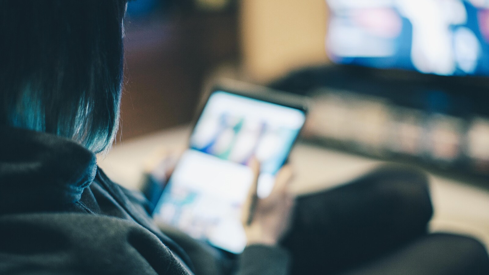 Une jeune femme devant son téléviseur et sa tablette