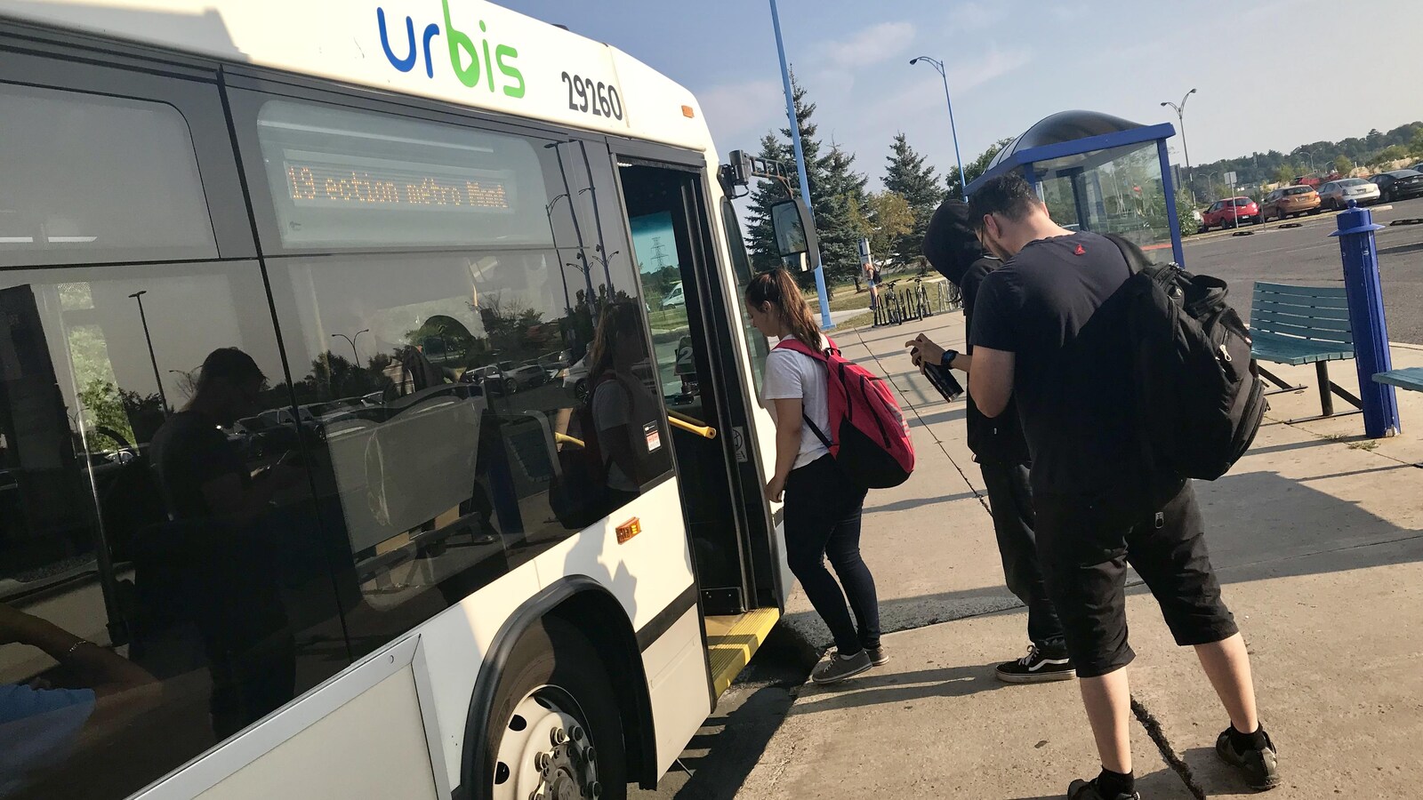 Des jeunes font la file pour entrer dans l'autobus.