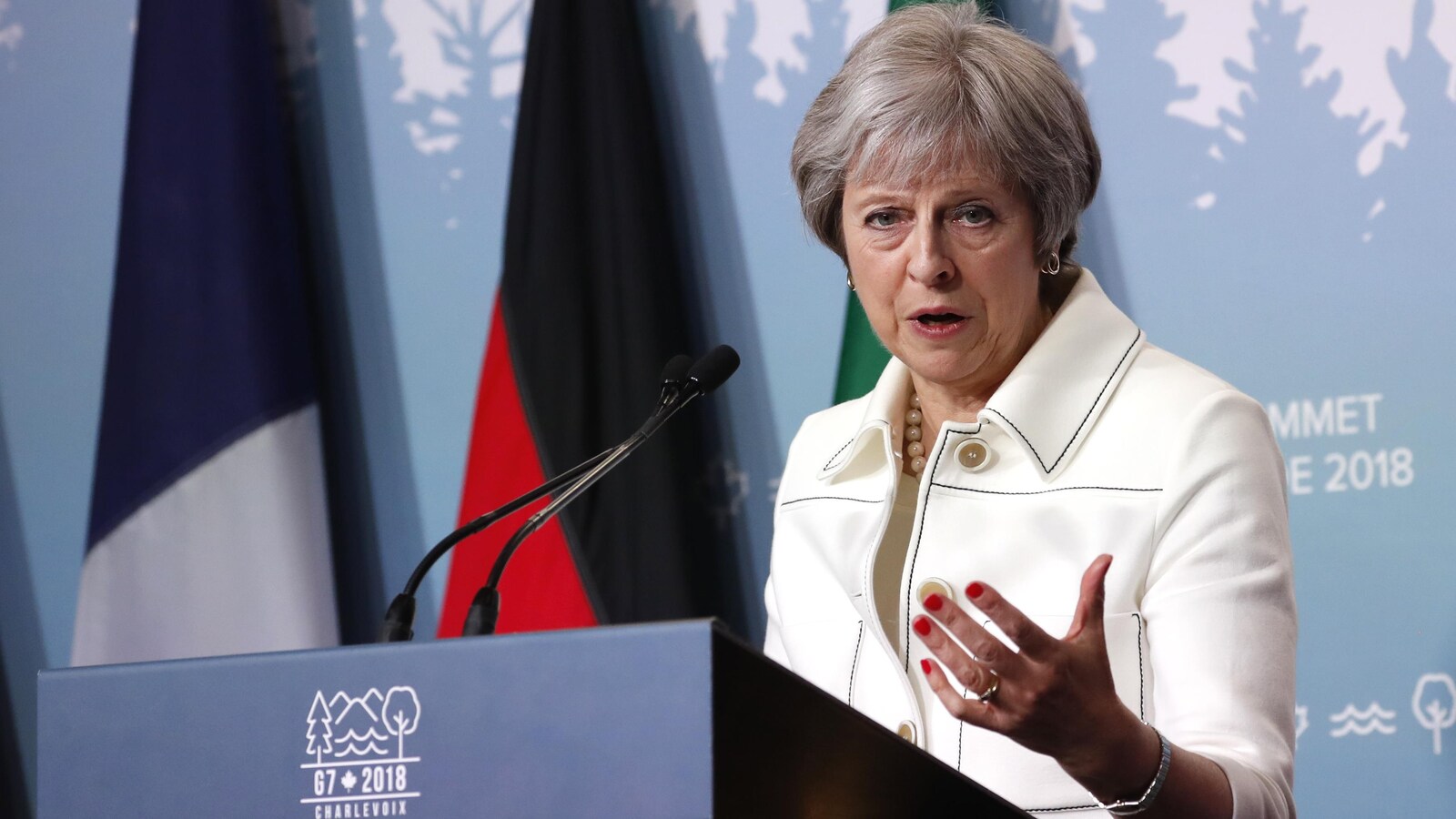 La première ministre britannique Theresa May lors du Sommet du G7 tenu à La Malbaie prend la parole derrière une tribune.