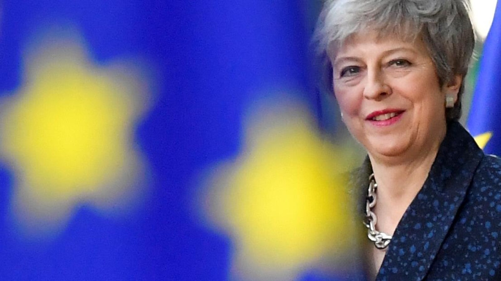 Theresa May entre deux drapeaux européens.