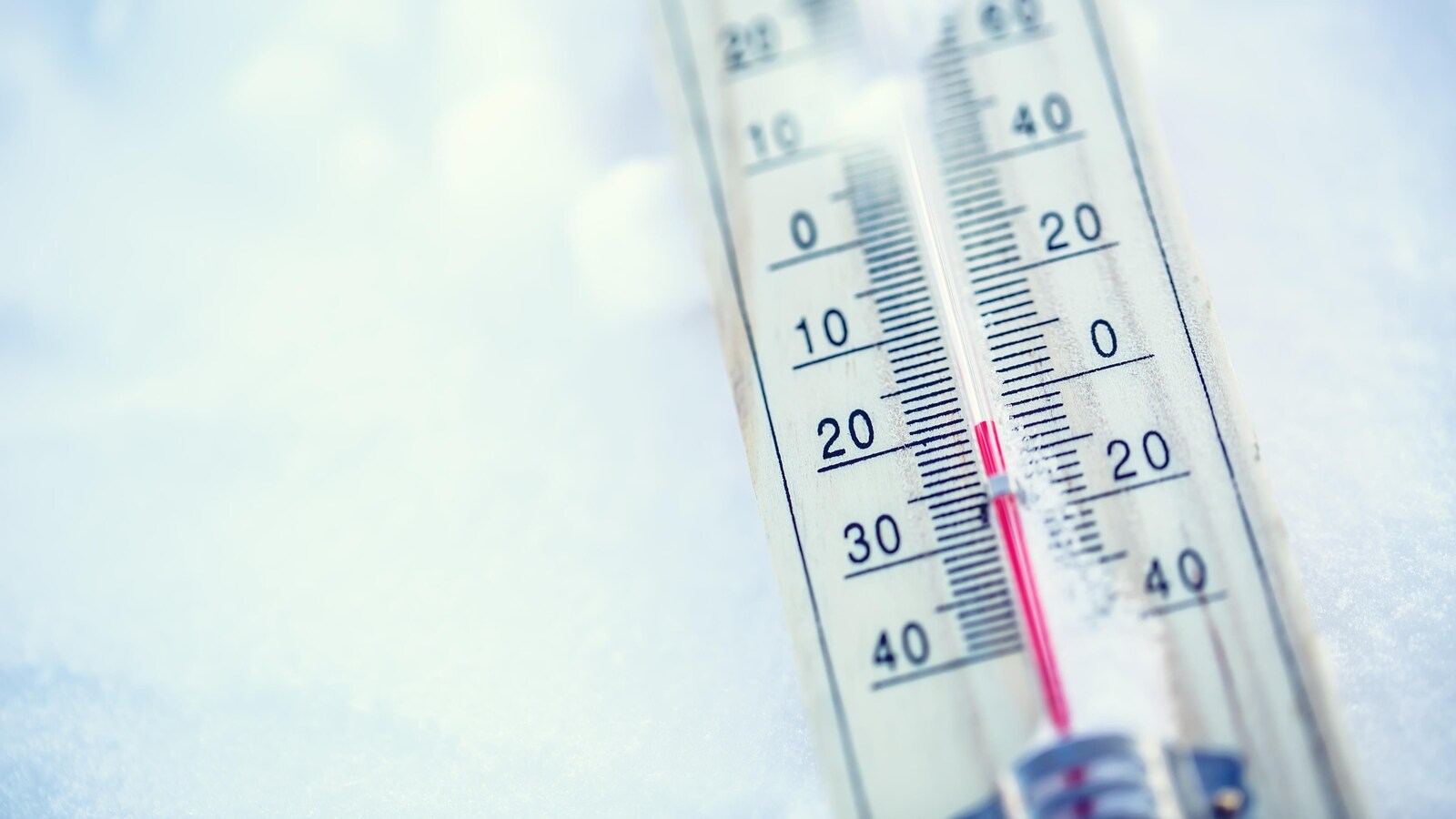 Un thermomètre affichant -20 degrés Celsius sur de la neige