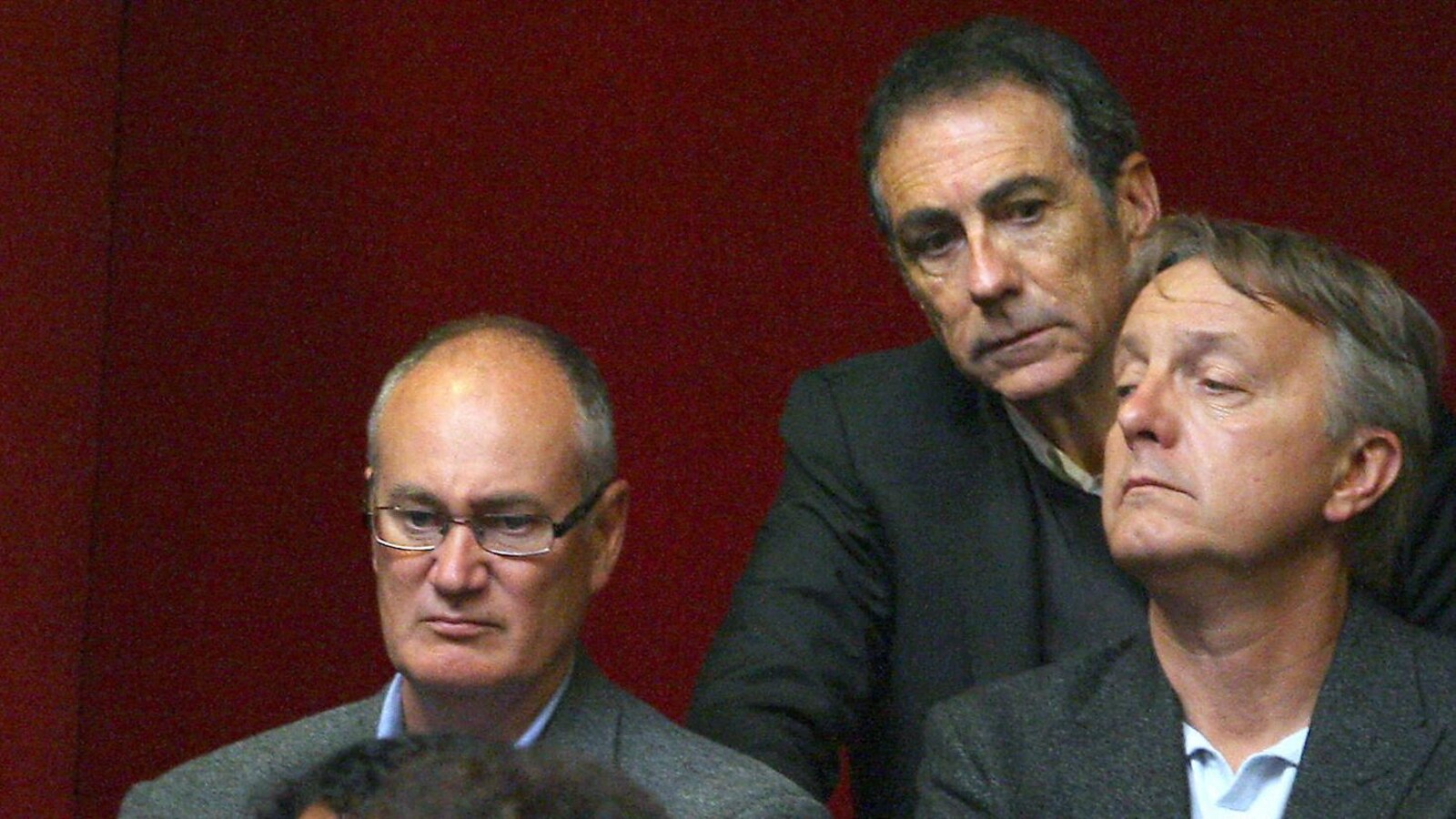 Trois hommes semblent regarder différentes choses.