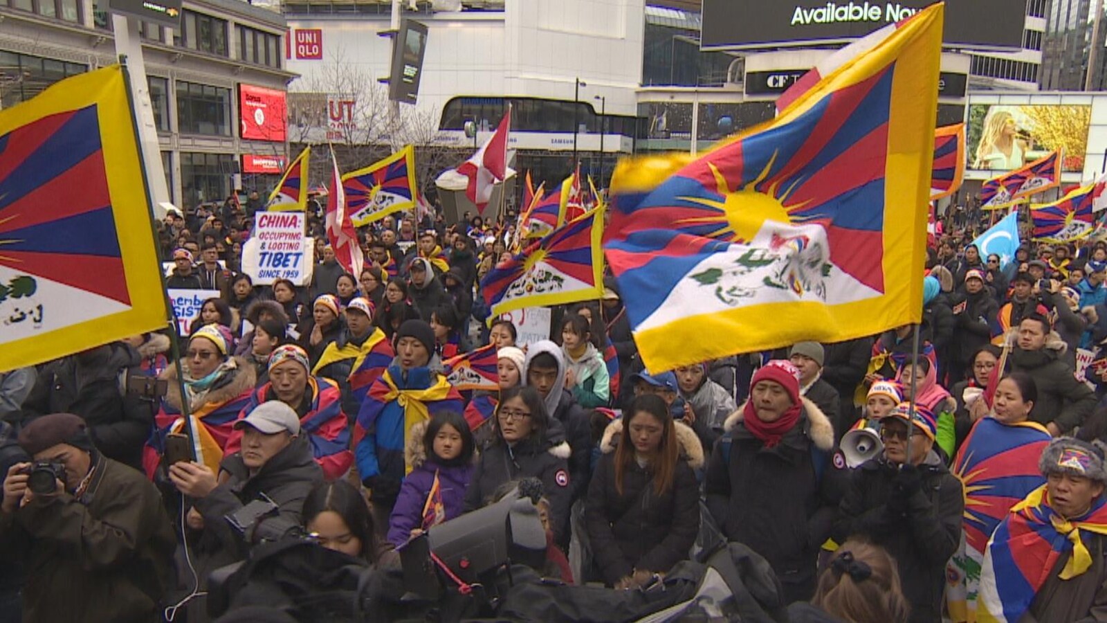 Une foule de manifestants arborant des drapeaux tibétains.