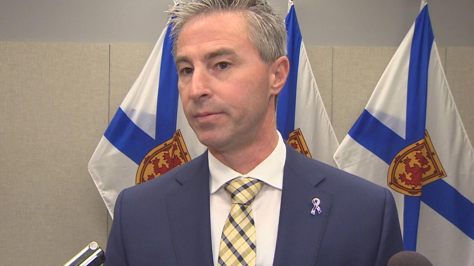 Tim Houston répond aux questions des médias devant des drapeaux de la Nouvelle-Écosse le 10 janvier 2019 à Halifax.