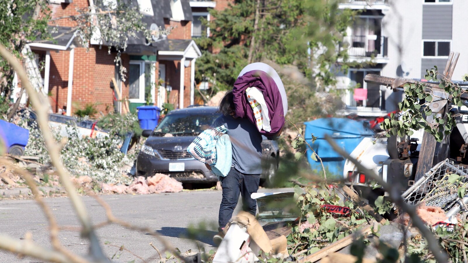 Un homme transporte des effets personnels alors que les résidents étaient autorisés à entrer dans leur maison et leur immeuble à Gatineau.