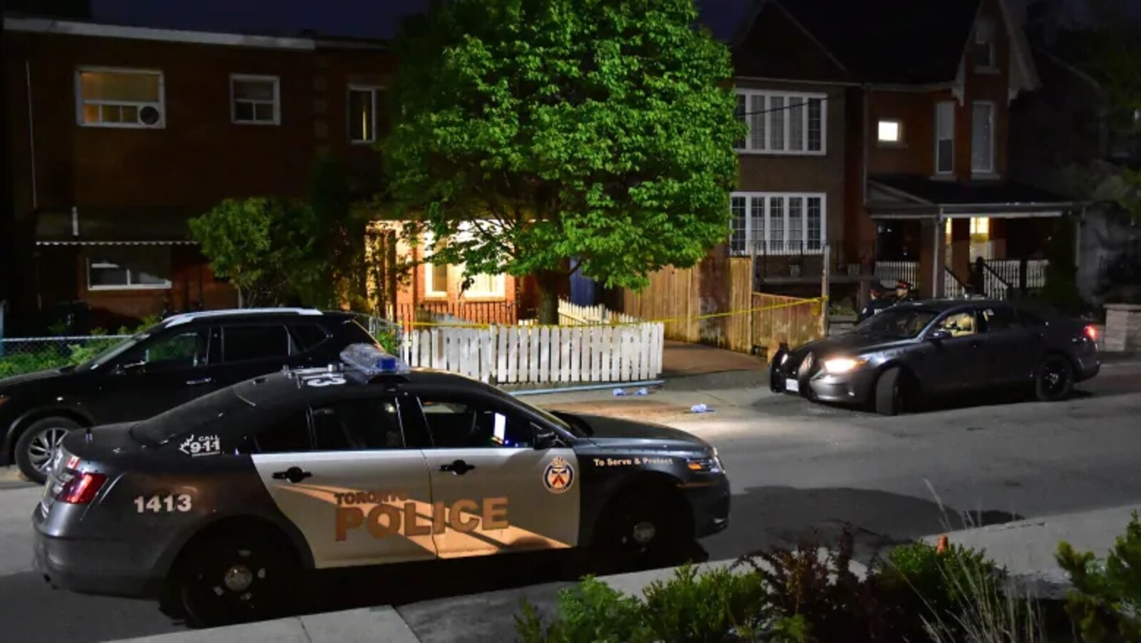 Photo de deux autopatrouilles stationnées près d'une maison en rangée.
