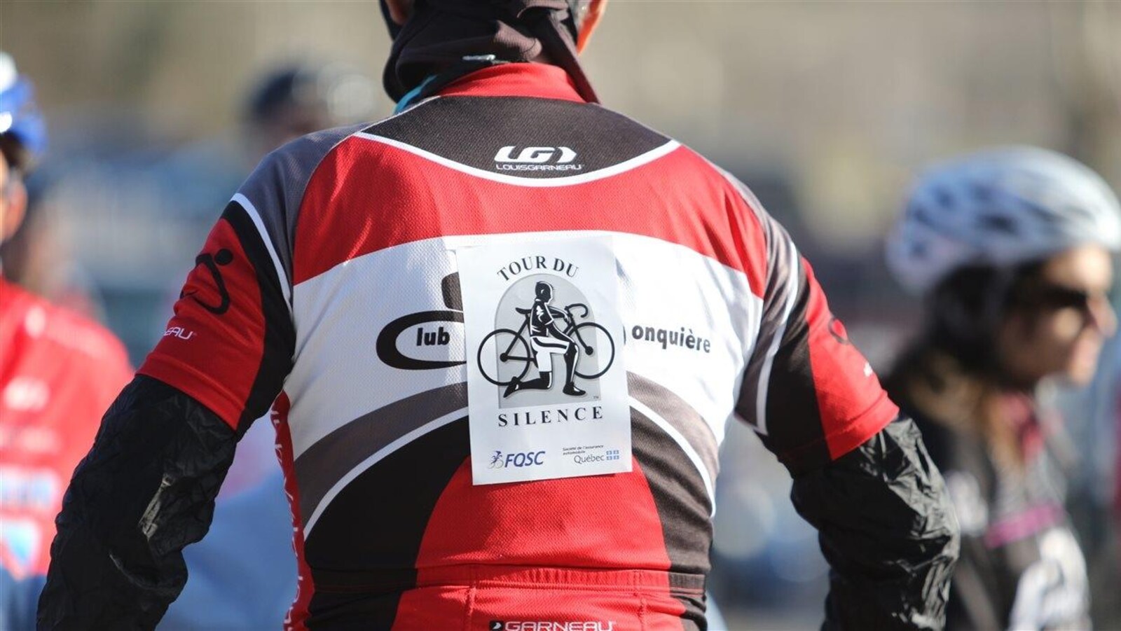 L'affiche du Tour du Silence accrochée dans le dos d'un cycliste.