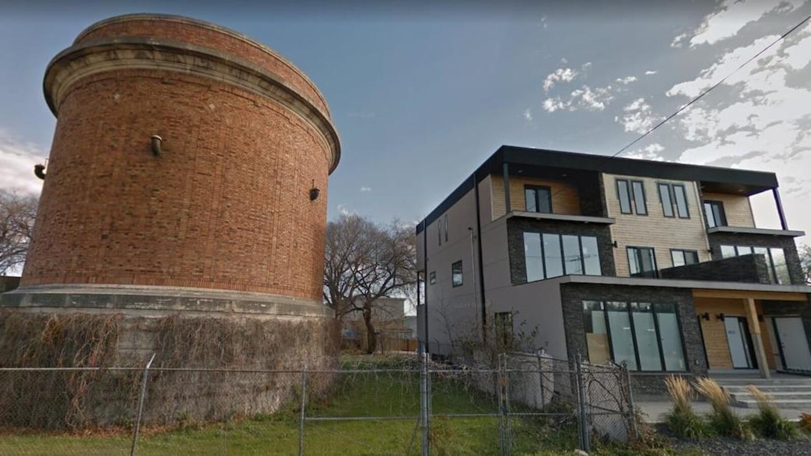Une tour d'eau à côté d'un condo neuf.