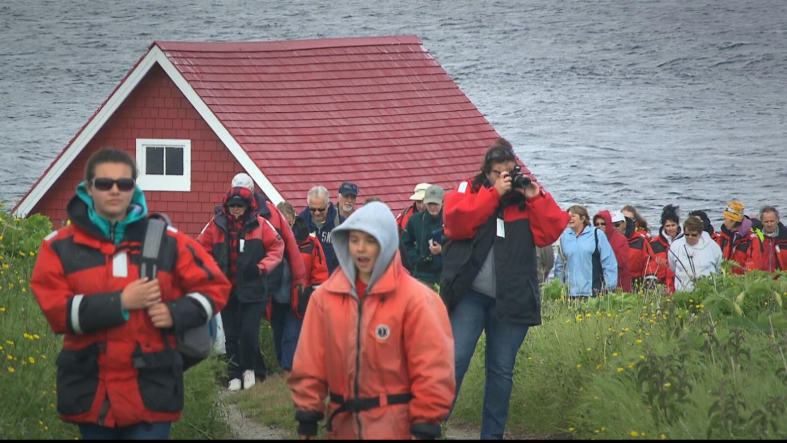 Plusieurs touristes prennent des photos et admirent le paysage de la Côte-Nord.